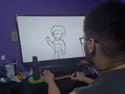 Luciano, jovem artista de 18 anos, desenhando um personagem do universo LITG em uma mesa digitalizadora.